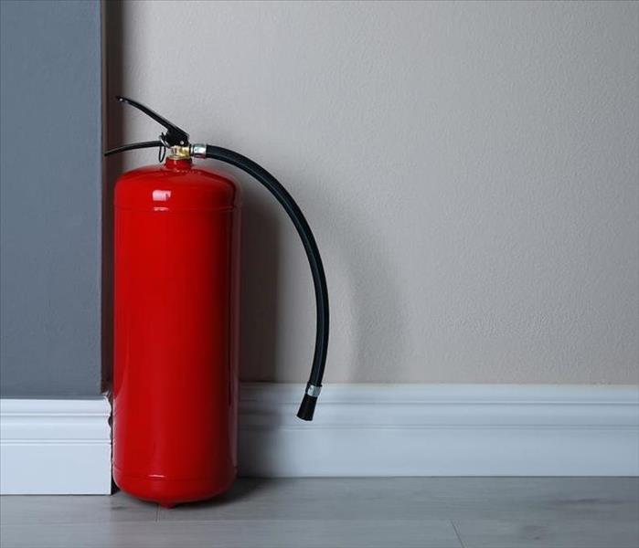 red fire extinguisher in front of wall